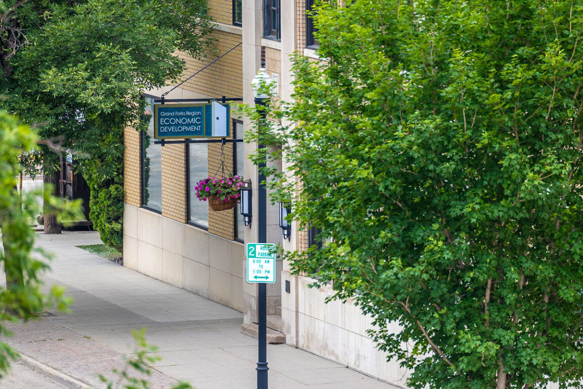 In downtown Grand Forks, North Dakota, a sign reads Grand Forks Region Economic Development Corporation outside of the EDC office where you can contact us.