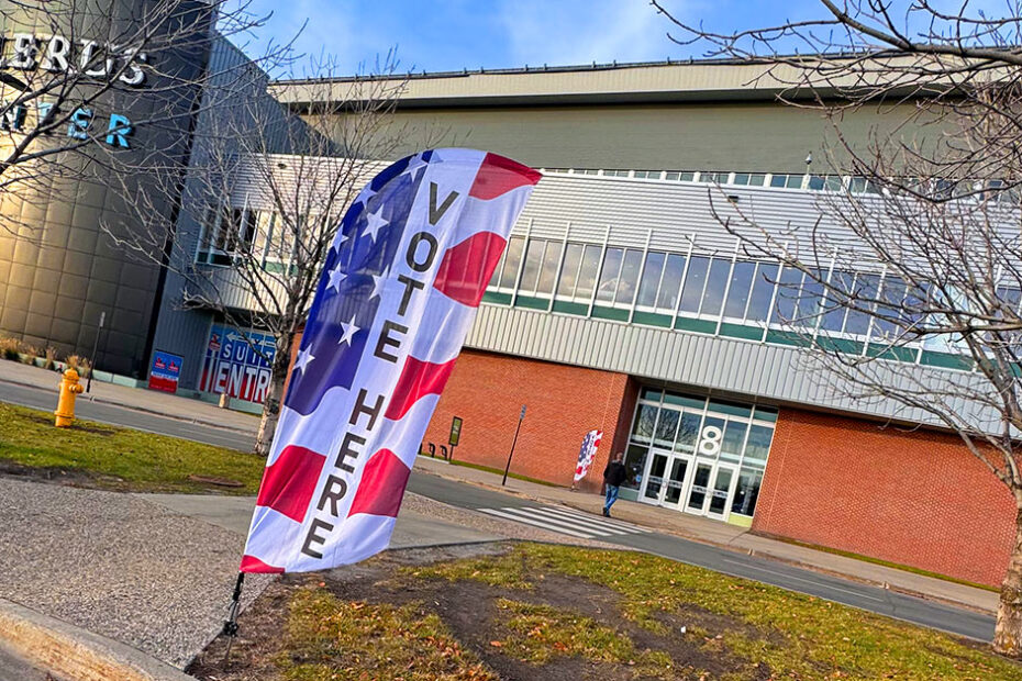 A flag reveals the word VOTE in front of the Alerus Center in Grand Forks.