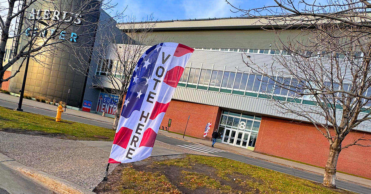 A flag reveals the word VOTE in front of the Alerus Center in Grand Forks.