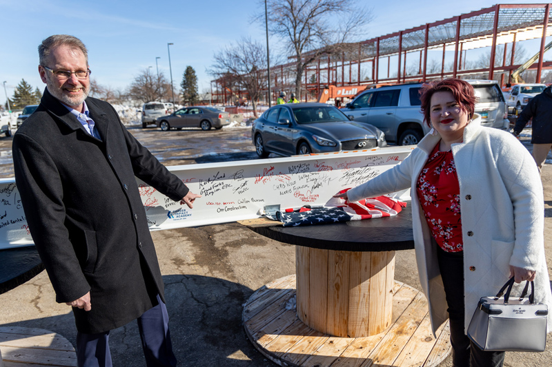 Keith Lund and Becca Cruger Point to their signatures on the signed beam that was the last to be raised for the Career Impact Academy