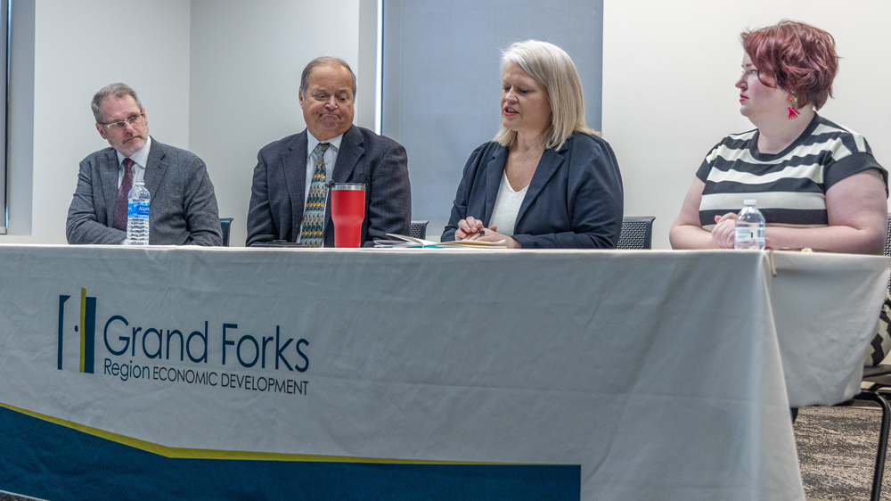From left to right, Keith Lund, EDC President & CEO; Barry Wilfhart, Chamber of GF/EGF President & CEO; Dawn Mandt, Executive Director of Red River Regional Council; Becca Cruger, EDC Director of Workforce Development sit at a table with an EDC table cloth.