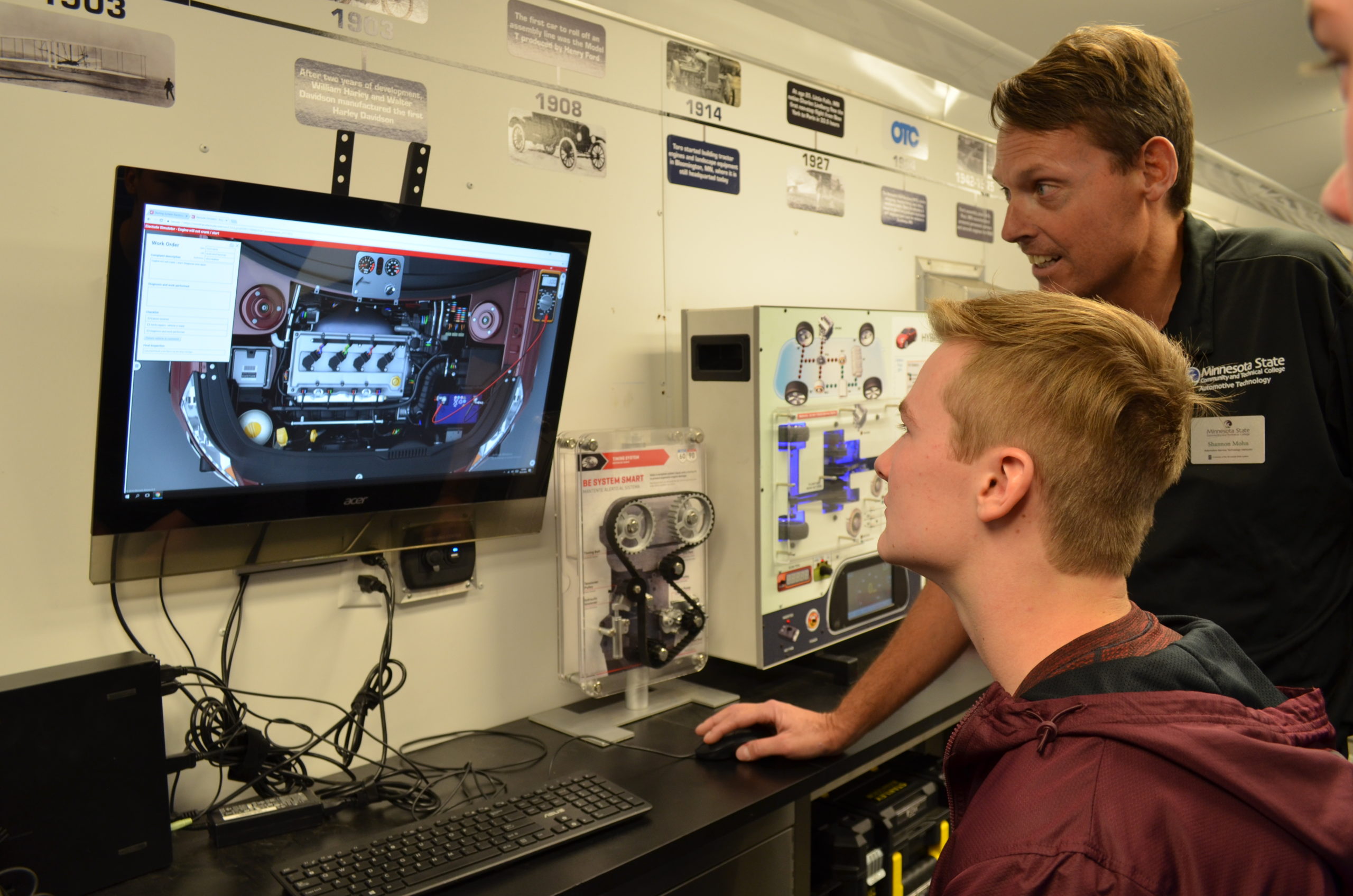 A student watching as a teacher explains an image on a computer in Grand Forks
