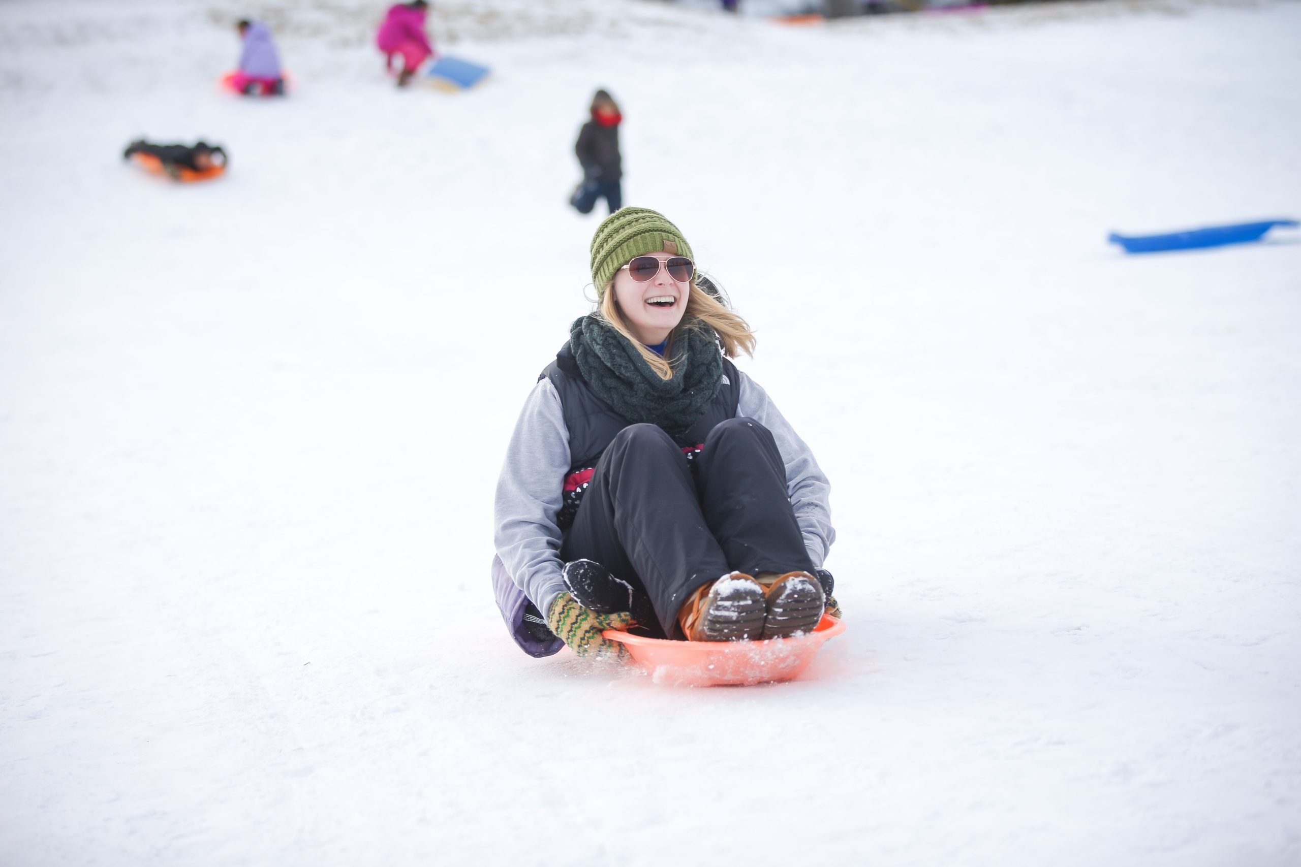 A young girl tubes down a snowy slope in Grand Forks
