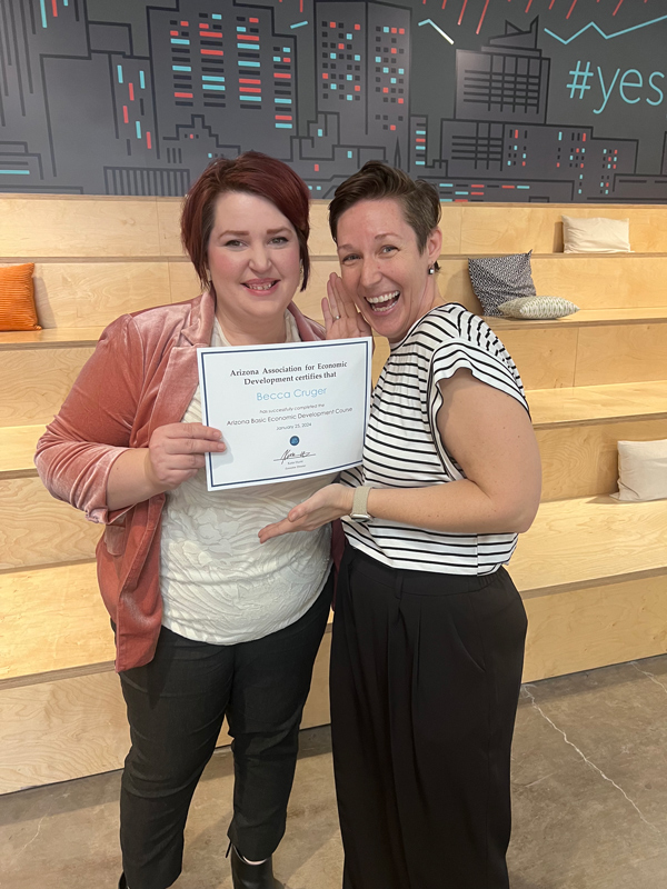 Becca Cruger stands holding a certificate after completing the basic economic development course in Arizona.
