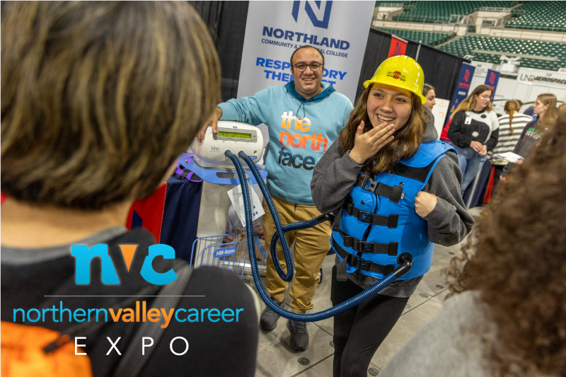 A student at the northern valley career expo stands wearing a respiratory therapy machine.