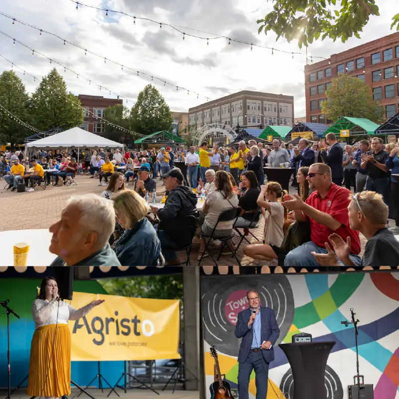 Community event in Grand Forks Town Square with speakers, Agristo banner, and large crowd gathered outdoors.