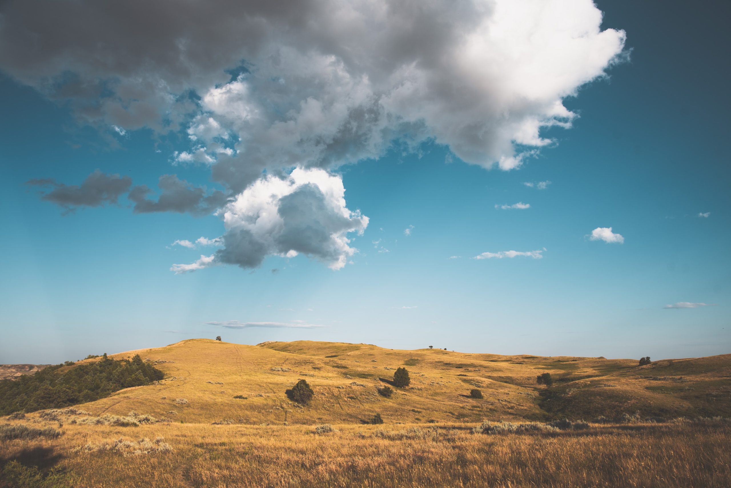 Image of rolling hills with a cloudy sky in Grand Forks