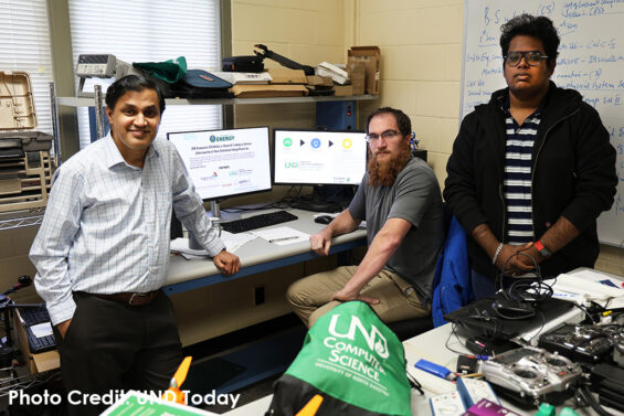 Prakash Ranganathan, associate professor of Electrical Engineering and director of the Center for Cyber Security Research at the UND College of Engineering & Mines (left), Jamison Jangula, a cybersecurity analyst at the College of Engineering & Mines, and graduate student Shree Ram Abayankar Balaji stand in the lab where they conduct cybersecurity research